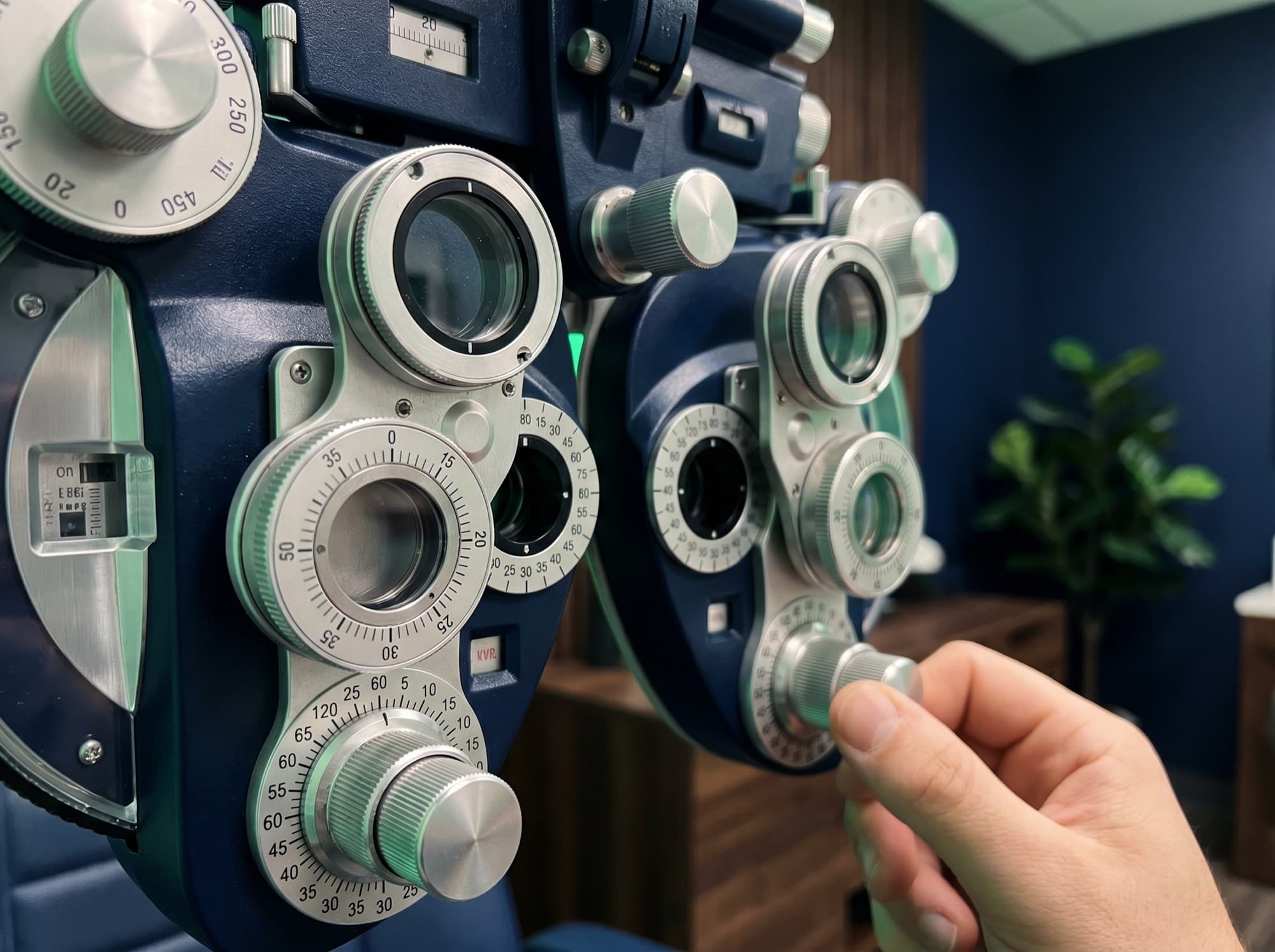 Close view of a phoropter's silver lens dials in the exam room